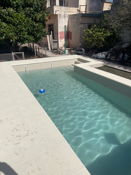 Detalle del agua y el borde de una piscina construida por Cepiscinas