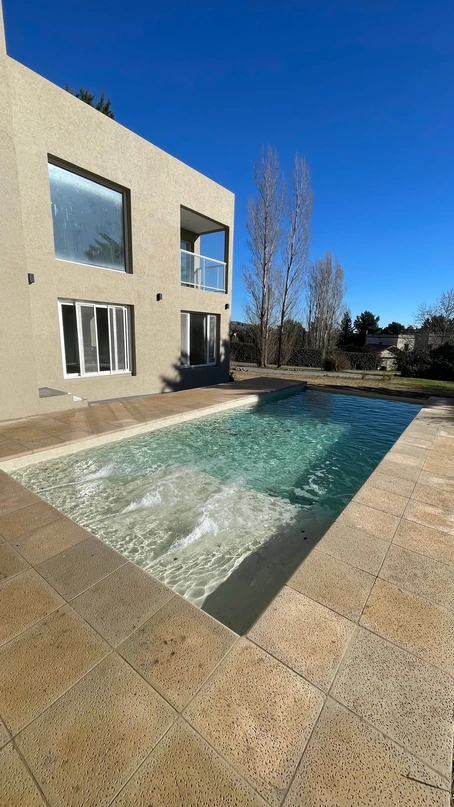 Piscina junto a una vivienda con escalones de acceso